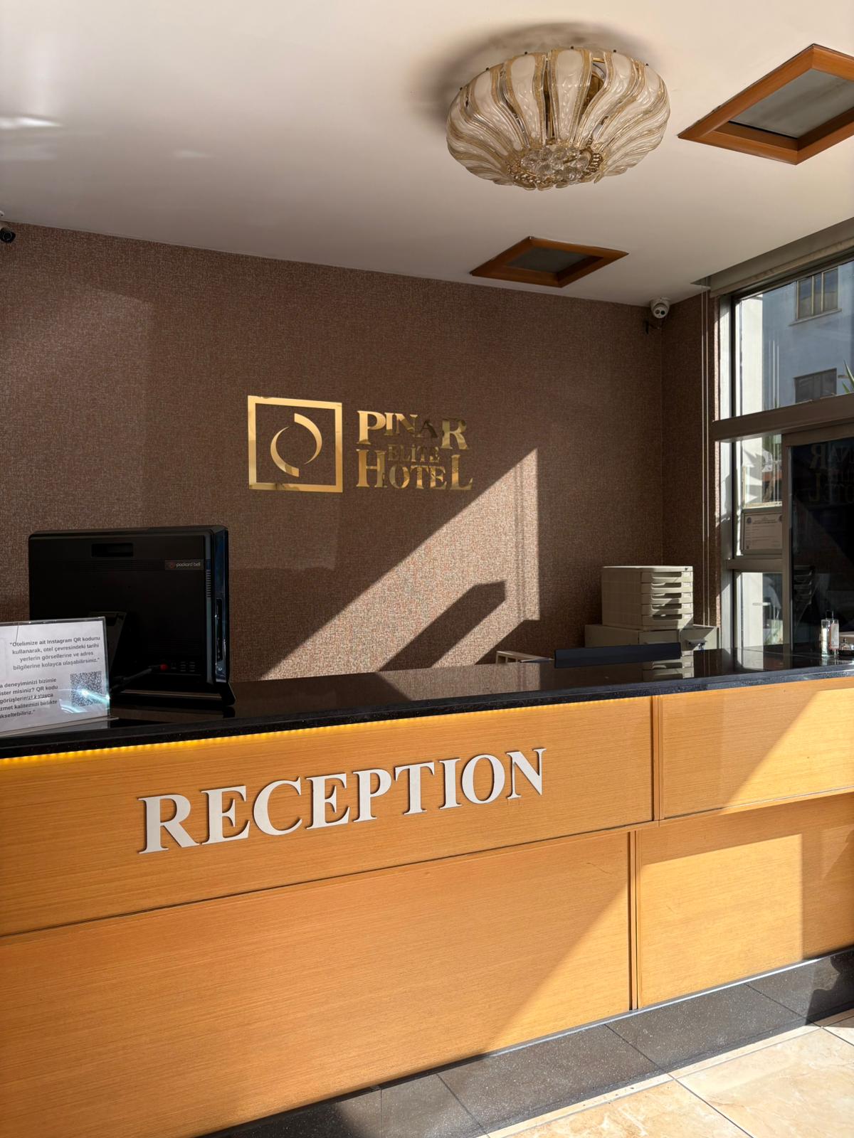 Resepsiyon ve duvardaki otel logosu